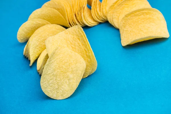 Eine Menge Kartoffelchips Einer Reihe Auf Blauem Hintergrund — Stockfoto