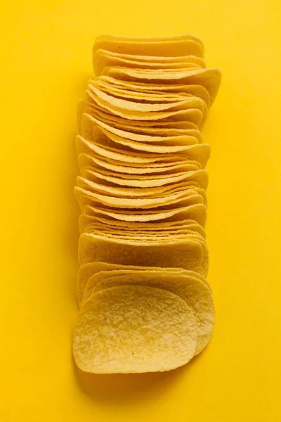 Viele Kartoffelchips Einer Reihe Auf Gelbem Hintergrund — Stockfoto
