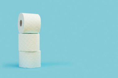 Tuvalet kağıdı açık mavi arkaplanda yuvarlanıyor.