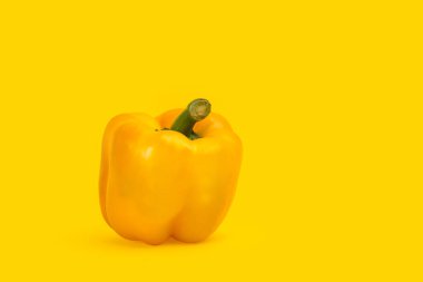 Sarı biber sarı arkaplanda izole edilmiş, sağ tarafta kopyalama alanı var.