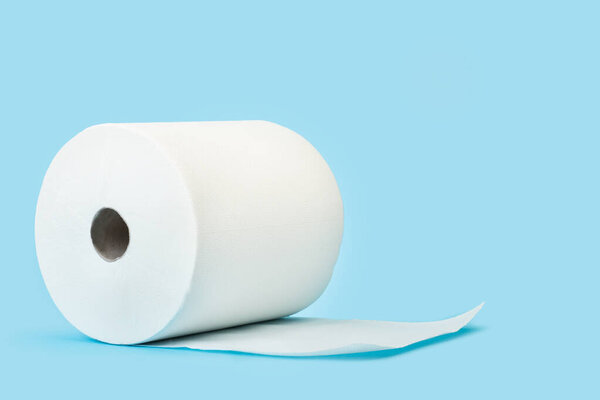 Большой рулон бумажного полотенца на светло-голубом фоне
