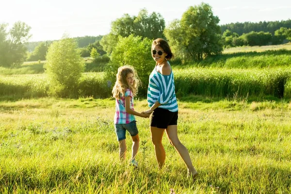 Lycklig vuxen kvinna leker utomhus med hennes dotter barn flicka. — Stockfoto