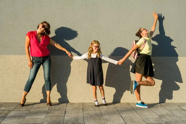 Matka a dcera studenti drží za ruce jít do školy. — Stock fotografie