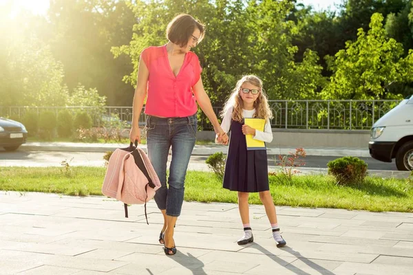 Mom and schoolgirl of primary school holding hands. — Stock Photo, Image