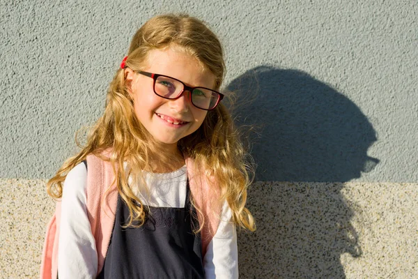 Sevimli kız okulda tek tip gülümsüyor. 