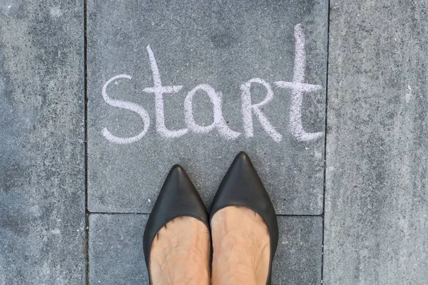 Los pies de mujer de negocios se enfrentan a la palabra "inicio " — Foto de Stock