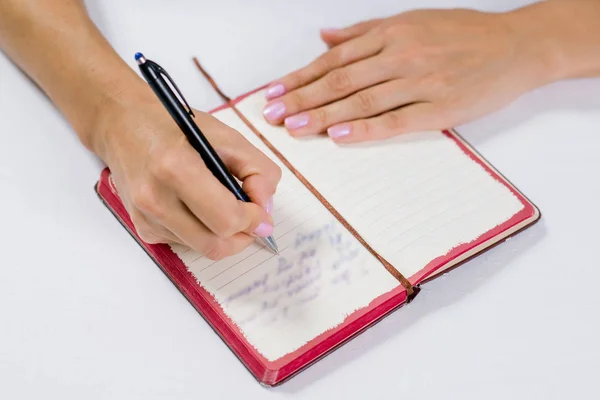 Hand writing in open notebook on table — Stock Photo, Image