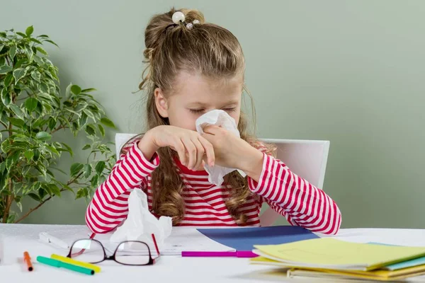 Cute  young girl child in glasses sneezing in a tissue blowing — Stock Photo, Image