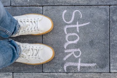 Beyaz spor ayakkabı ve word başlangıç ayakkabılı kadın bacakları