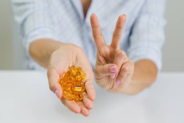 Eller bir kadın tutarak balık Omega-3 kapsül ve gösteren v yağ