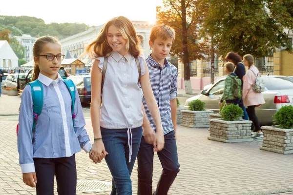 Un niño va a la escuela cogido de la mano . — Foto de Stock