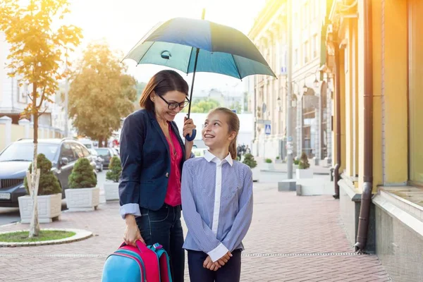 Mulher bonita com filha andando juntos para a escola sob um — Fotografia de Stock