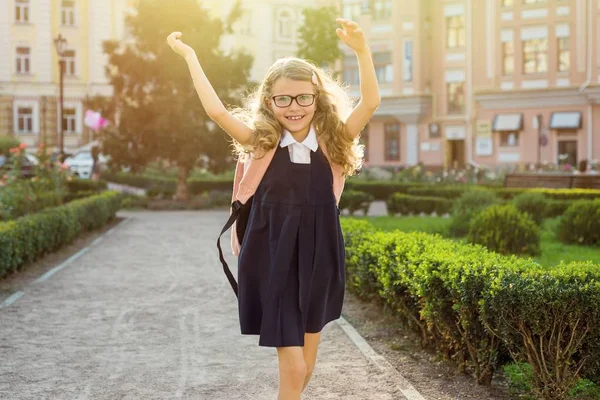 Portret van een jonge schoolmeisje loopt langs de weg in een stad — Stockfoto