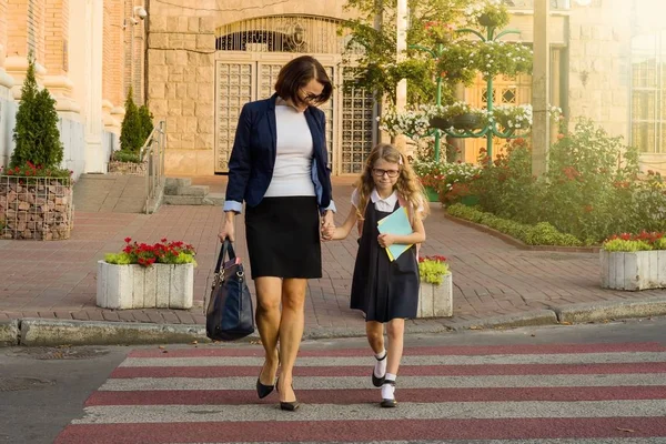 Mujer y niño - una joven colegiala cogida de la mano, en cebra cr — Foto de Stock