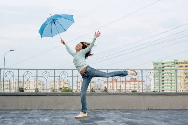 Bir kız bir şemsiye şehrin zemine karşı çalışır.