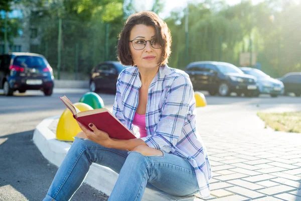 Vrouw is ontspannen in de stad lezen van een boek — Stockfoto