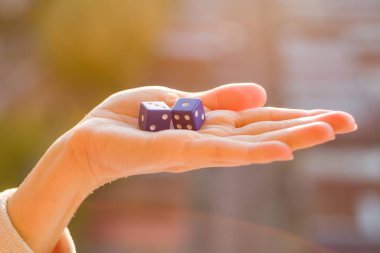 Zar 1 3 kadın elinde, gün batımı arka plan. Kumar aygıtları.