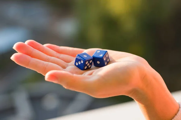 Tärning 1 2 i kvinnliga handen, sunset bakgrund. Gambling enheter. — Stockfoto