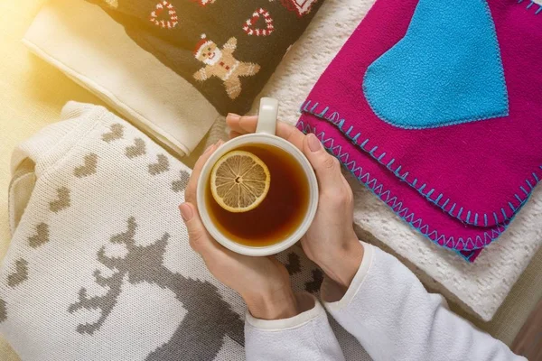 Winter background picture pile of warm woolen clothes on table, a cup of hot tea. — Stock Photo, Image