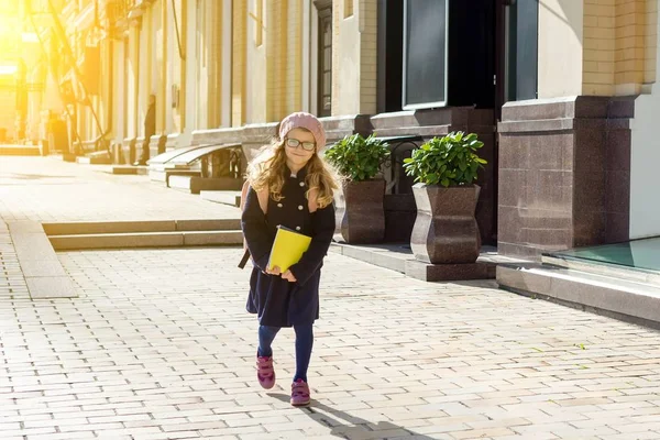Elegante niña con una mochila en un abrigo y boina francesa correr a la escuela . —  Fotos de Stock