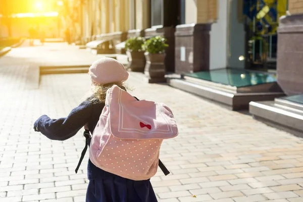 Elegante bambina con uno zaino, in cappotto e berretto francese correre a scuola . — Foto Stock