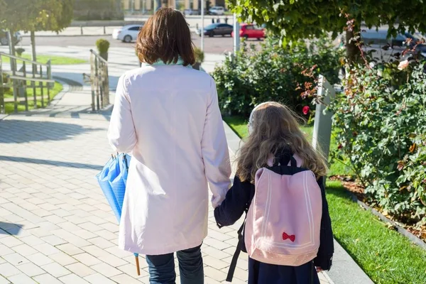 A mãe a levar a criança à escola. De mãos dadas, fundo - cidade de outono . — Fotografia de Stock