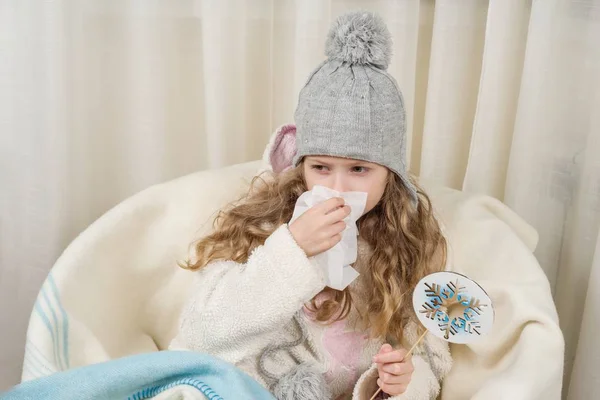Kind niest zu Hause in Taschentuch, die Saison ist Herbst-Winter. — Stockfoto