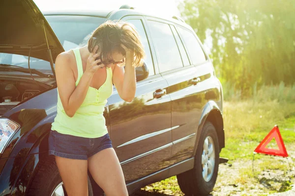 Woman with a black car that broke down on the road. Making telephone call to get help with the broken car. — Stock Photo, Image