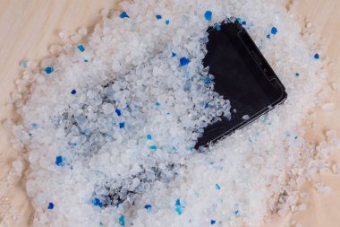 Your phone wet - putting it in a bag of silica gel filler to absorb the moisture. Wet smartphone repair in silica gel filler from your cat's clipart