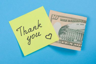 Sticker with word thank you, and cash money. Blue background clipart