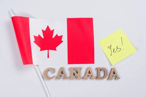 Bandeira do Canadá, palavra Canadá em letras abstratas de madeira, etiqueta com a inscrição sim. Fundo branco — Fotografia de Stock