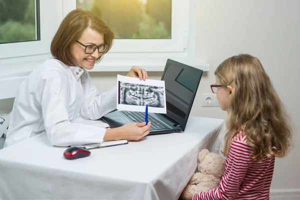 Menina em consulta com o dentista, olhando para raio-x dental — Fotografia de Stock