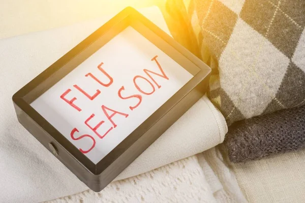 Grippesaison - Text im Rahmen. Hintergrund warme Wollkleidung. — Stockfoto