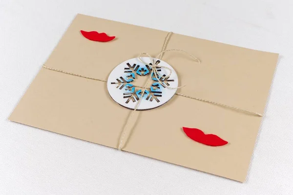 Pacchetto, lettera, confezionato in una busta vintage con un fiocco di neve simbolico. Capodanno e le vacanze di Natale. Una lettera di una femmina-femmina — Foto Stock