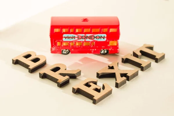 Storbritannien utträde ur Europeiska unionen, Brexit ordet abstrakt i vintage bokstäver, bakgrund double decker buss leksak modell. — Stockfoto