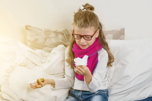 Mignon jeune fille enfant dans lunettes éternuer dans un tissu soufflage — Photo