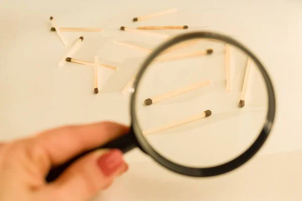 Match sticks with brown heads in a row. Matches under magnifier, white background.