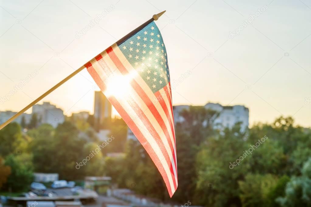 American flag from the window on sunset background