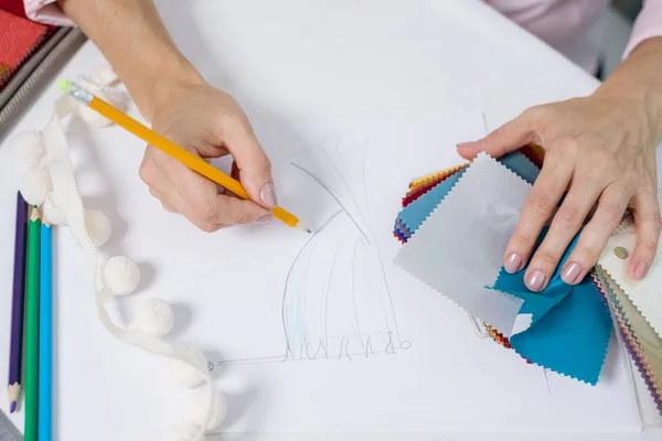 Interieur ontwerper tekent bij balie in kantoor met potlood — Stockfoto