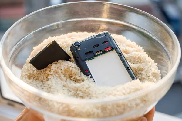 Dropped your phone in water - The fix is rice. Wet smartphone repair in rice — Stock Photo, Image