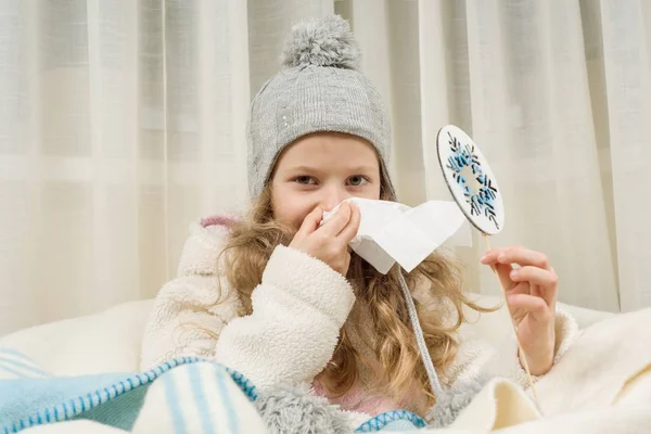 El niño estornuda en un pañuelo en casa, la temporada es otoño invierno . — Foto de Stock