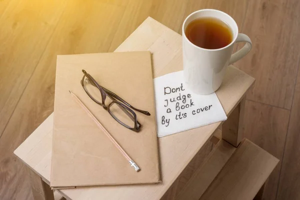 Dont judge a book by its cover - a handwritten inscription on a napkin. — Stock Photo, Image