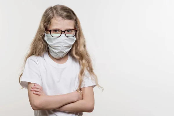 Gadis bertopeng medis. Pada latar belakang putih, dalam T-shirt dasar putih, menyalin ruang . — Stok Foto