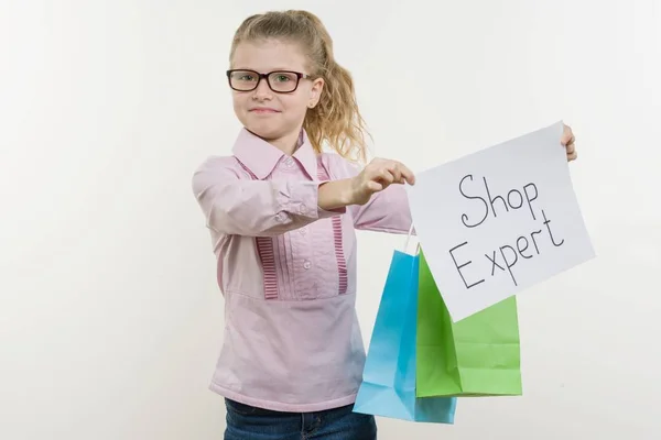 Девочка держит листок бумаги со словом SHOP EXPERT. Белый bakgrounde, пространство для копирования — стоковое фото