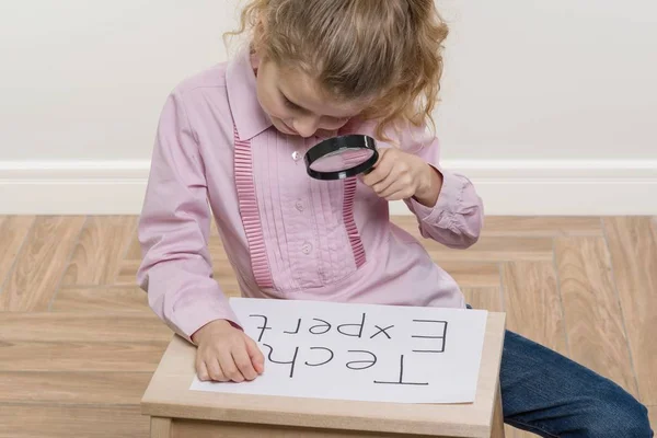 Menina criança segurando pedaço de papel com uma palavra TECH EXPERT . — Fotografia de Stock