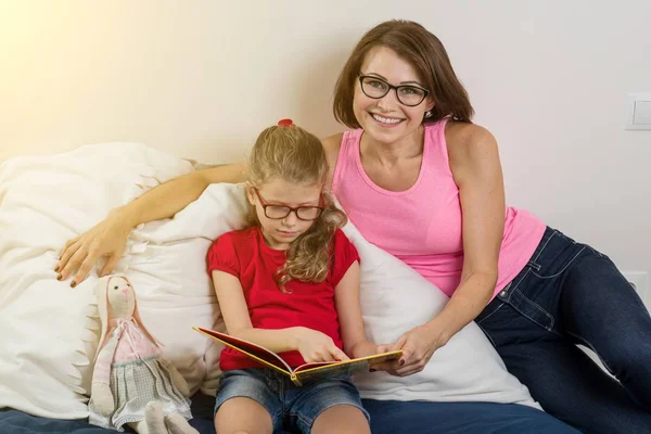 Mom helps me read a book to my little daughter. They learn let — Stock Photo, Image