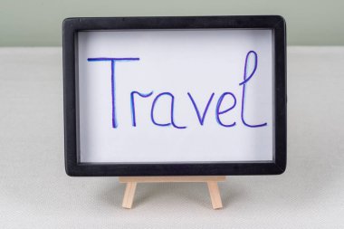 Metin Word'de seyahat, siyah çerçeve, beyaz masa üzerinde.