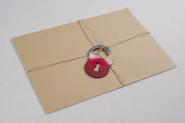 Een geheime envelop, een perceel dat is gebonden met een touw, met een symbolische slot. Open de sluis. — Stockfoto
