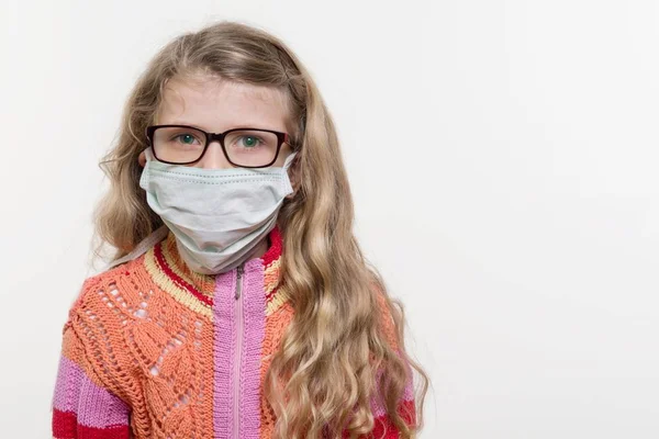 Girl child in medical mask. On a white background, copy space. — Stock Photo, Image