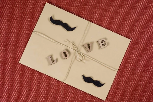 Fondo del Día de San Valentín, sobre kraft marrón con la palabra amor, con una cuerda kraft. Pareja hombre-hombre — Foto de Stock